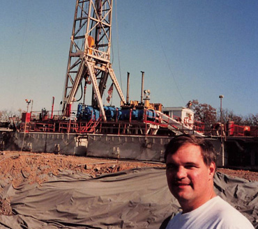 Photo of Mike Oxley in front of an oil rig